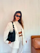 Bandolera morral color marrón, con asa de hombro y correa regulable. Cuenta con un bolsillo frontal con cierre y otro bolsillo trasero con cierre.