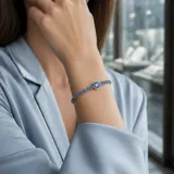 Pulsera de plata 925 con diseño de cadena fina engastada con pequeñas circonias azules y un dije central circular de mayor tamaño con piedra azul.
