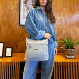 Bandolera color bordó de símil cuero con dos bolsillos frontales con cierre, un bolsillo trasero y tres bolsillos internos. Incluye correa larga regulable a tono.