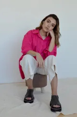 Camisa fucsia de corte oversize con cuello clásico y mangas largas.