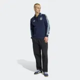 Campera deportiva Adidas de la selección de Alemania, color azul marino con detalles en celeste. Presenta cuello tipo polo, cierre frontal, bolsillos laterales y las icónicas tres tiras de la marca en las mangas. Incluye el logo del Trifolio y el escudo de la federación alemana en el pecho.