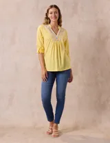 Blusa amarilla de manga 3/4 con escote en V y bordado multicolor. Largo de manga regulable con presilla y botón. Marca Ruby Rd.