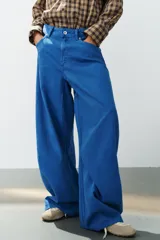 Jeans de tiro medio estilo balloon en color negro, con diseño de cinco bolsillos, trabillas para cinturón y cierre frontal con cremallera y botón metálico.