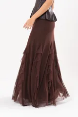 Pollera larga color chocolate confeccionada en microtul, totalmente forrada, con diseño fluido y volados en cascada que aportan movimiento.