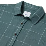 Camisa de manga corta color verde con estampado a cuadros blancos, cuello clásico y bolsillo en el pecho.