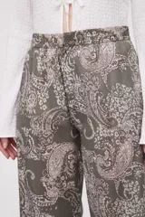 Pantalón de algodón de tiro medio, corte recto y largo, con estampado paisley en tonos verde militar y beige/blanco.