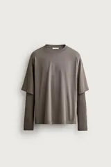 Camiseta de corte relajado confeccionada en algodón con elasticidad, con cuello redondo y diseño de manga larga con efecto doble. Presenta un acabado con efecto lavado.