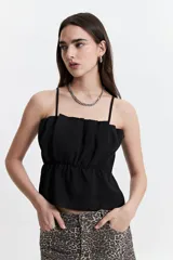 Top negro con breteles finos, escote recto con detalle de volados y corte elastizado en la cintura.