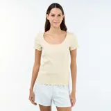 Camiseta de manga corta confeccionada en punto canalé, en color beige vainilla, con escote redondo y terminaciones con volados sutiles en cuello, mangas y ruedo.