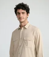 Camisa de manga larga color beige, con cuello camisero y dos bolsillos frontales con cierre en solapa.