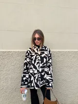 Buzo de peluche con estampado animal print de leopardo, de corte oversize, cuello redondo y mangas largas.