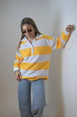 Sweater de punto a rayas horizontales amarillas y blancas, con cuello polo y mangas largas.