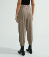 Pantalón jogger Marfinno color beige, confeccionado en suedine con cintura elástica y cordón ajustable. Presenta detalles perforados en los bolsillos laterales y en las costuras laterales, además de puños elásticos en los tobillos.