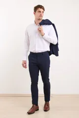 Ambo de corte entallado en color azul oscuro, compuesto por saco de dos botones con solapa clásica y pantalón de vestir a juego.