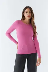 Remera gris de punto canalé, con escote redondo y mangas largas.