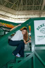 Pantalón Oxford negro de lycra gruesa, con corte acampanado, tiro medio y tajos laterales.