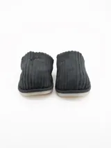 Pantuflas abiertas color gris con textura acanalada y forro interno de corderito sintético blanco.