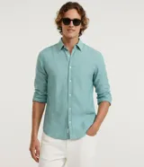 Camisa masculina de corte comfort, confeccionada en una mezcla de lino y algodón. Presenta cuello inglés, manga larga y cierre frontal abotonado.