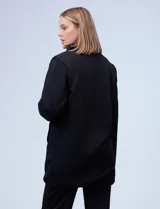 Cárdigan largo reversible color blanco. Un lado es de sherpa y el otro capitoneado. Tiene bolsillos delanteros.