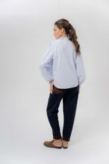 Pantalón de gabardina azul marino, de corte barrel y tiro bajo, con detalles en pana marrón en la pretina y en el ruedo interior vuelto.