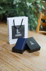 Billetera azul de cuero PU y aluminio con tecnología RFID blocking. Cuenta con tarjetero de aluminio para 6 tarjetas, 2 espacios adicionales para tarjetas, espacio con ventana transparente para cédula de identidad, espacio interno para 6 billetes y bolsillo monedero exterior con cierre.