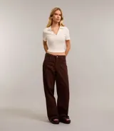 Blusa de cuello polo y manga corta, confeccionada en tejido rib de algodón con elastano. Presenta un diseño ajustado al cuerpo con escote en V y textura acanalada.
