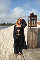 Pantalón de corte amplio y tiro medio, confeccionado en tela crepe color beige, con diseño fluido y holgado.