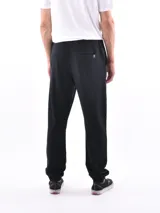 Pantalón deportivo negro, tipo jogging, con cordón ajustable en la cintura y puños elásticos en los tobillos.