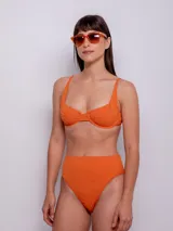 Parte inferior de bikini tiro alto color naranja, con textura de flores.