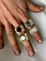 Anillos regulables hechos a mano con base ancha y piedra natural redonda engarzada. Disponibles en versiones de bronce dorado y alpaca plateada con variedad de piedras.