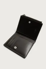 Billetera y monedero de piel, color marrón oscuro, con compartimento principal para billetes, ranuras para tarjetas y cierre lateral con cremallera.