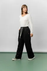 Pantalón deportivo de corte wide leg con caída relajada. Presenta cintura elastizada con cordón ajustable, bolsillos laterales y un interior frizado para mayor abrigo.