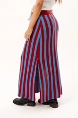 Pollera midi tejida a rayas verticales en color rojo y celeste, con pretina elástica, cordón de ajuste y tajos laterales profundos.