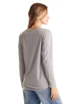 Buzo de tejido fino con escote henley y cierre de botones. Presenta detalles acanalados en hombros, puños y ruedo, con una silueta cómoda y terminación redondeada en la parte inferior.