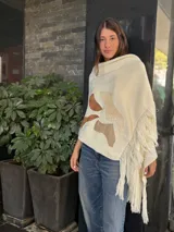 Pashmina color crema tejida en lana merino con apliques de cuero en tonos marrones y flecos en los bordes.
