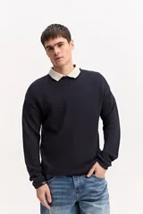 Sweater de punto texturizado color azul marino, de manga larga, con cuello polo en color beige contrastante.