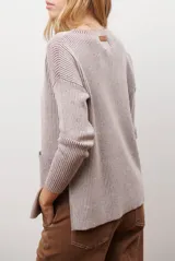 Buzo de tejido de punto acanalado en color beige, con cuello redondo, mangas largas y un bolsillo frontal aplicado en la parte inferior.