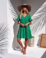 Vestido corto de lino color verde, con escote en V, mangas cortas con volados y diseño en capas escalonadas.