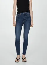 Jeans de corte skinny y tiro alto, confeccionados en tejido denim de algodón con elastano. Presentan diseño clásico de cinco bolsillos, cierre de cremallera con botón y trabillas en la cintura.