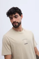 Remera de algodón color beige, de manga corta y corte regular, con estampa en la espalda inspirada en el océano.
