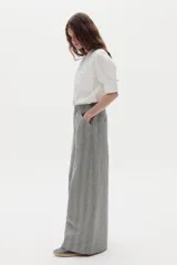 Pantalón gris de lino con diseño a cuadros, tiro medio-alto, pierna ancha y bolsillos laterales.