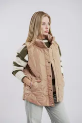 Chaleco puffer color borgoña con diseño capitoneado, cierre frontal con cremallera y botones a presión, y dos bolsillos laterales.
