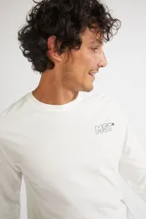 Remera de manga larga color mostaza, con cuello redondo y estampado frontal con las siglas MST en contorno verde.