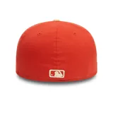 Gorra New Era modelo 59FIFTY cerrada, de color rojo con visera plana en tono beige. Presenta el logo bordado en relieve en el frente y un parche conmemorativo bordado en el lateral.