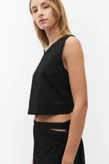 Top corto negro sin mangas con escote redondo.