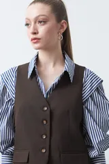 Chaleco sastrero color marrón oscuro, con escote en V, cierre frontal de botones y pinzas de entalle.