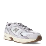 Championes New Balance modelo 530, con diseño retro-deportivo. Presentan una capellada de malla transpirable en color blanco con refuerzos sintéticos en tonos gris y lila. Incorporan entresuela con tecnología ABZORB para mayor amortiguación y suela de goma en color marrón.