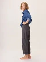 Pantalon de corte recto y tiro medio, confeccionado en tejido de lana con sutiles rayas verticales. Presenta bolsillos traseros aplicados, costuras reforzadas en las rodillas y ruedo con dobladillo.