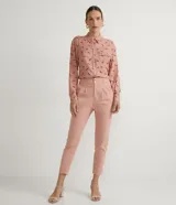 Camisa de viscosa color rosa con estampado de caballos en marrón. Tiene cuello camisero, cierre con botones, mangas largas, un bolsillo frontal y detalle de vivo contrastante en el bolsillo.