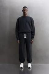 Buzo negro de cuello redondo, corte relaxed fit, confeccionado en tejido de algodón con interior de rizo y acabado en rib.